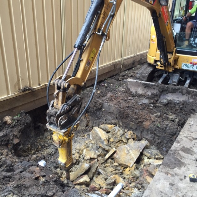 Rock breaker on excavator to install 900 pit in solid rock.