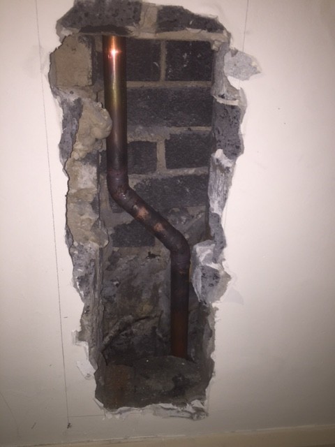 We cut a hole into the service duct to be able to remove the old pipe and install the new section of copper pipe. 